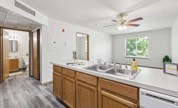 a kitchen with a sink and a ceiling fan