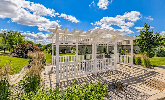 a white gazebo with white benches and a white pavilion