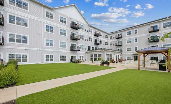a large green lawn in front of an apartment building