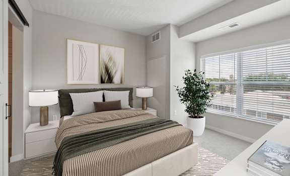 A bedroom with a large bed and a potted plant.