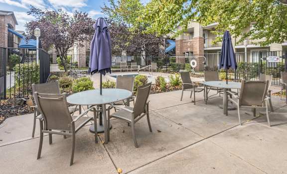 an outdoor patio with tables and chairs and umbrellas