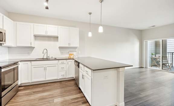 a renovated kitchen with white cabinets and stainless steel appliances