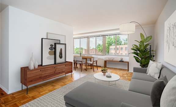 A living room with a grey couch, a wooden cabinet, a coffee table, and a large window.