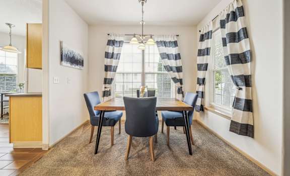 A dining room with a table and chairs.