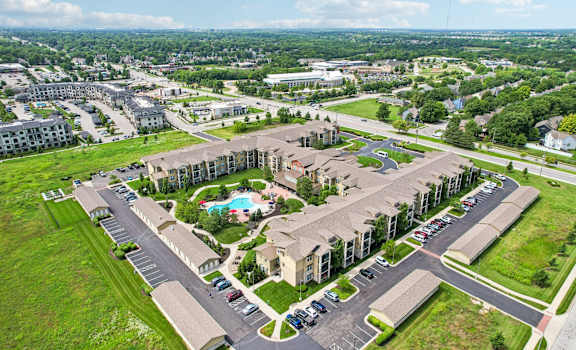A large apartment complex with a pool in the middle of the courtyard.