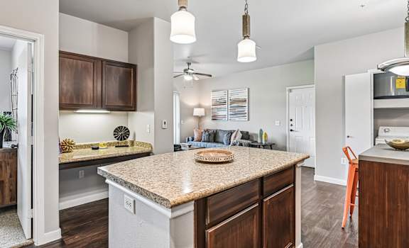 A kitchen with a countertop and a ceiling fan.