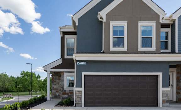 a home with a garage door in front of it at The Clearing at ONE28, Olathe, 66062