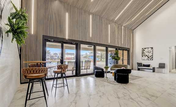 a living room with marble flooring and a table with high chairs