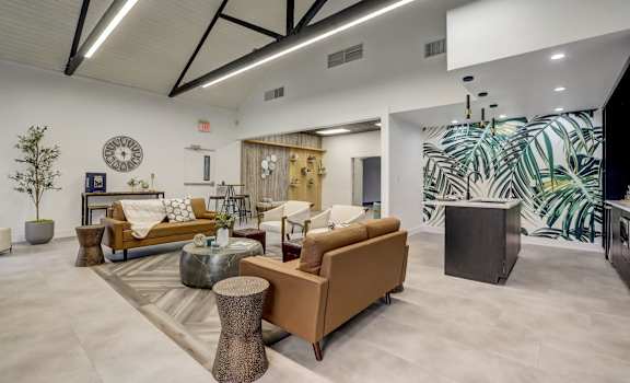 a lobby with couches and chairs and a clock on the wall