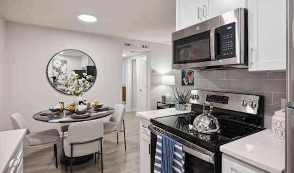 A modern kitchen with a dining table and chairs at St. Andrews Reserve Apartments in Wilmington, NC