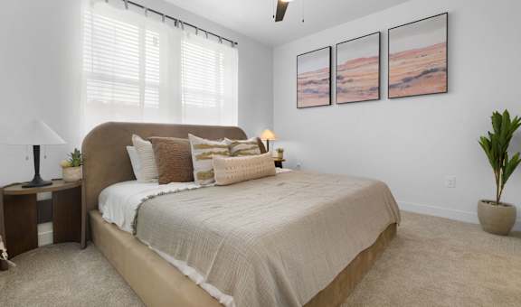 A bedroom with a large bed and a ceiling fan.