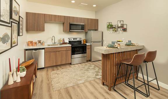 A modern kitchen with a wooden island and bar stools.