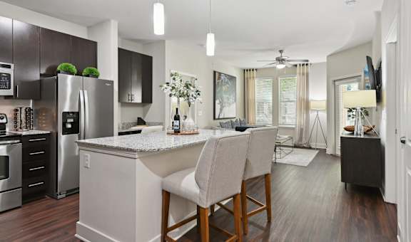 A modern kitchen with a center island and bar stools.