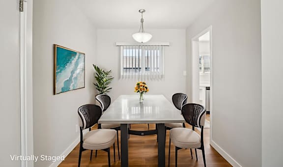 A dining room with a table and chairs.