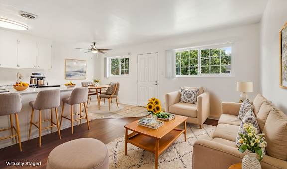 A living room with a bar area and a dining area.