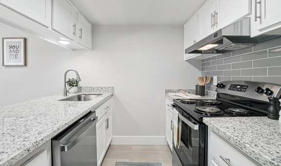 A kitchen with a granite countertop and a stove top oven.