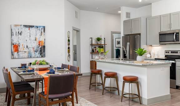 A modern kitchen with a dining table set for four.