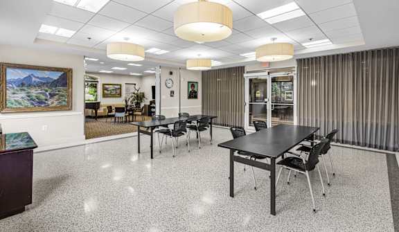 a conference room with tables and chairs in the center of it