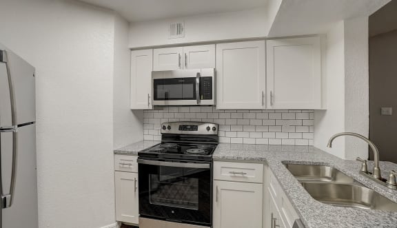 a kitchen with a white counter top and black cabinets  at Hidden Palms Apartment Homes, Tampa, Florida