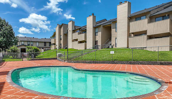 A swimming pool in front of apartment buildings.