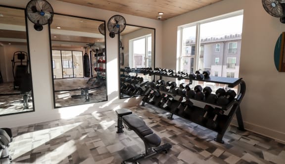 a rendering of a fitness center with exercise equipment and a checkered floor at The Wren Apartments, Lawrenceville, 30043