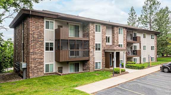 a brick apartment building with balconies and a sidewalk