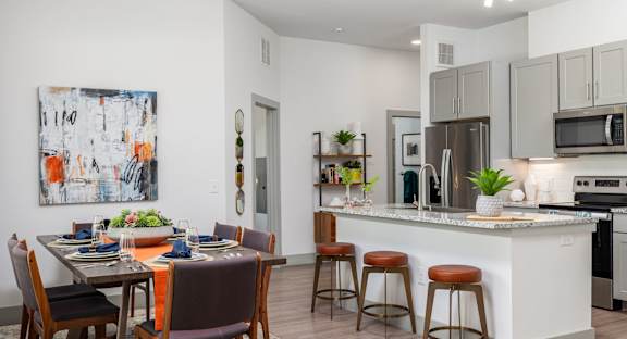A modern kitchen with a dining table set for four.