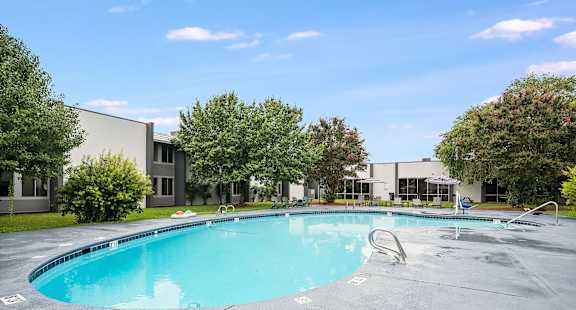 A large outdoor swimming pool with a slide.