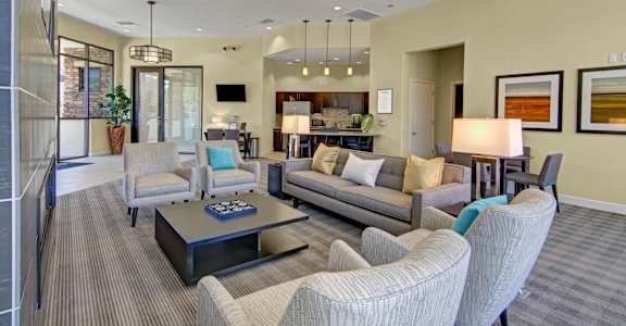 A living room with a grey couch, a coffee table, and a lamp.