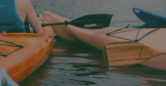 A person is kayaking on a calm body of water.at 422 at the Lake, Austin
