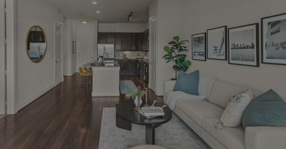 A living room with a couch, coffee table, and pictures on the wall.