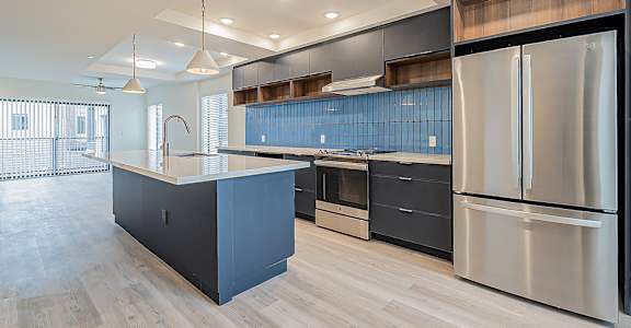 a large kitchen with stainless steel appliances and blue cabinets
