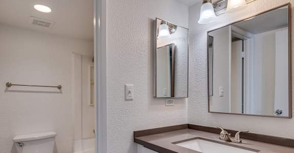 a bathroom with a sink and a toilet and a mirror at Tides on Southern, Mesa