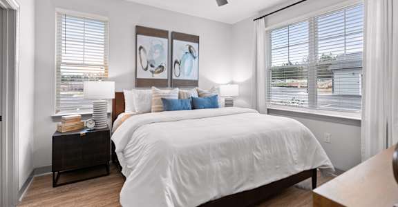 A bedroom with a large bed and a ceiling fan.