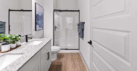 A white bathroom with a walk-in shower and a toilet.