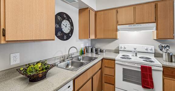 A kitchen with a white stove and wooden cabinets.