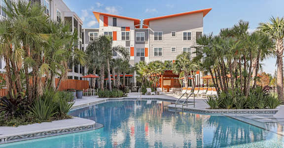 Swimming Pool with Seating and Umbrellas at Tapestry Headwaters in Kissimmee, FL