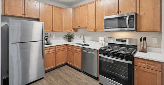 A kitchen with wooden cabinets and stainless steel appliances.