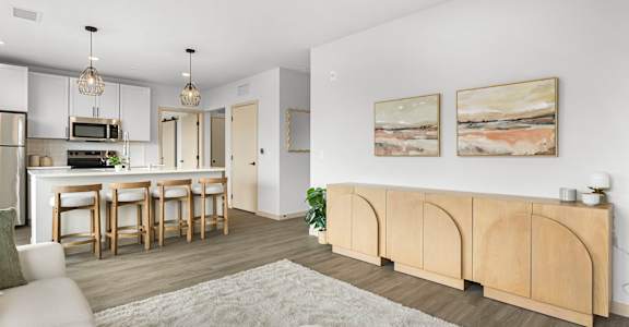 A modern kitchen with a dining area and a living room.