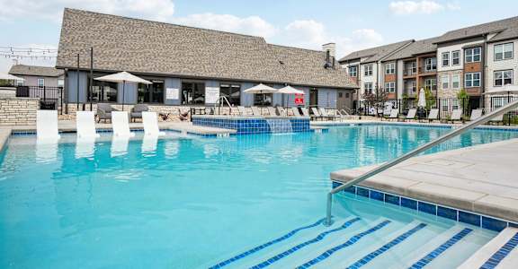 A large swimming pool with a building in the background.