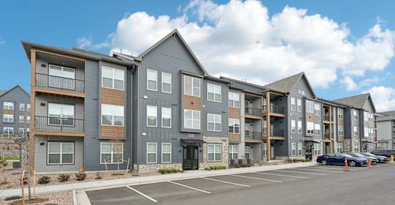Large apartment building with parking lot at The Garrison Luxury Apartment Homes, Fountain, CO