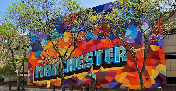 A large mural on a building with the word "MANCHESTER" written on it.