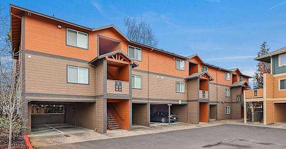 Apartment complex with brown and orange siding and a clear blue sky.