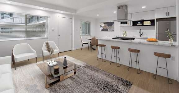 A modern kitchen with white cabinets and a bar area.