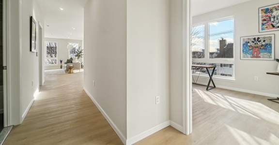 A long hallway with a table and chairs in the distance.