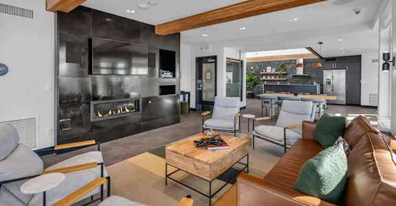 A modern living room with a fireplace and a brown leather couch.