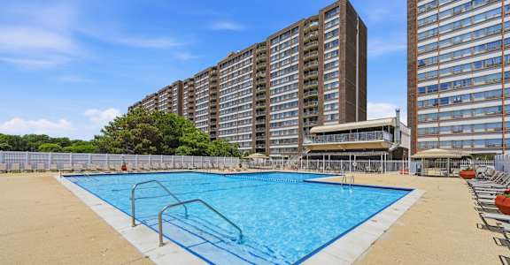 A large swimming pool in front of apartment buildings.