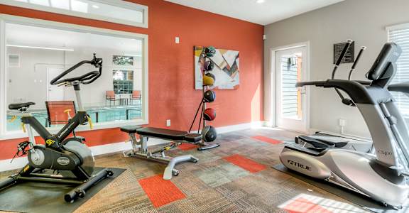 A home gym with a treadmill, elliptical trainer and a stationary bike.