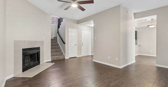 A spacious living room with a fireplace and hardwood floors.