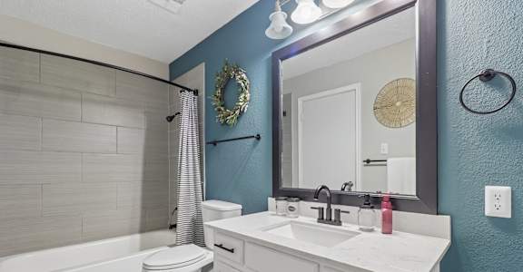 A white bathroom with a white toilet and a white sink.
